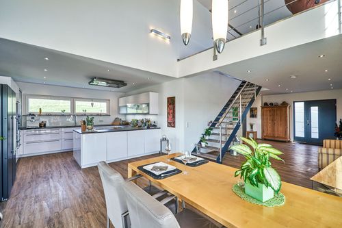 Die Küche des modernen Bungalows aus Holz im Bauhausstil mit mineralischem Außenputz mit Pool