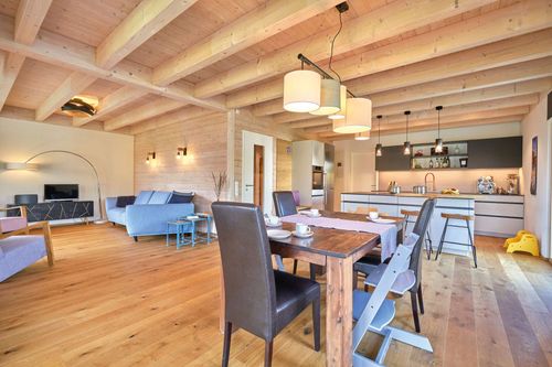 Der Wohn- und Essbereich des modernen Doppelhauses aus Holz mit Mischfassade aus mineralischem Außenputz und Holz