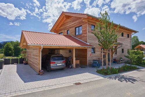 Modernes Holzhaus im Landhausstil mit durchgängiger Lärchenholzfassade und Holz-Alu-Fenstern