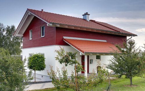 Eingang des Holzhauses im Landhausstil mit gemischter Fassade aus mineralischem Putz und Holz
