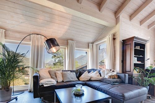 Die Sitzecke des Bungalows aus Holz auf Hanggrundstück mit ausgebautem Keller mit viel Glas
