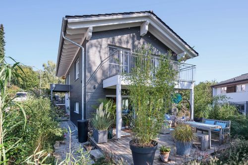 Schwedenhaus anthrazit mit weißen Fenstern und großer Holzterrasse