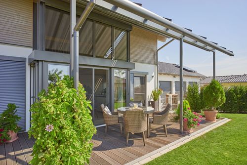 Die Terrasse des modernen Holzhauses mit Mischfassade aus Holz und Putz und komfortabler Ausstattung