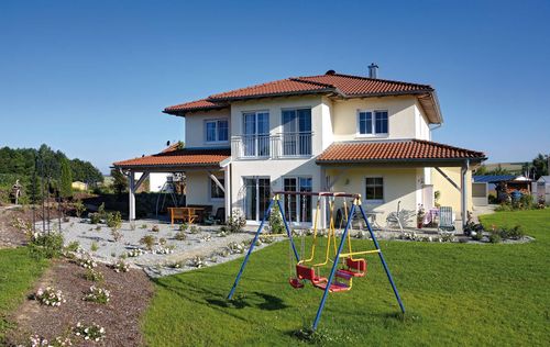 Modernes Holzhaus in mediterranem Stil mit mineralischem Außenputz